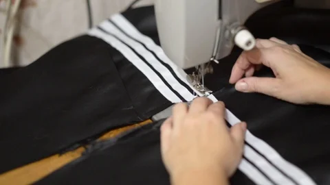 Close up side top view of cropped female hands sewing black fabric Stock Footage 121201037
