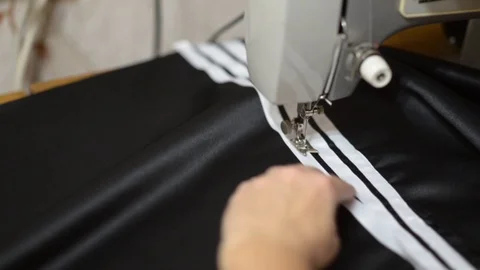 Close up side top view of cropped female hands sewing black fabric Stock Footage 121201039