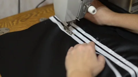 Close up side top view of cropped female hands sewing black fabric Stock Footage 121201062