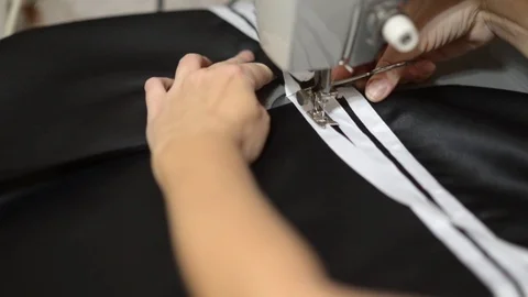 Close up side top view of cropped female hands sewing black fabric Stock Footage 121201065