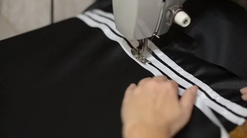 Close up side top view of cropped female hands sewing black fabric Stock Footage 121201069