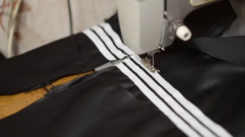 Close up side top view of cropped female hands sewing black fabric on profession Stock Footage 121201115