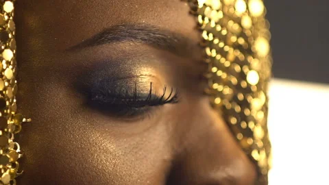 Close-up side view of the beautiful african woman is opening the eye covered Stock Footage 159421415