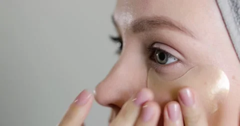 Close-up side view of beautiful caucasian woman using patches under eyes Stock Footage 151258772