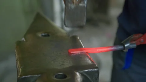 Close-Up Side View of Blacksmith Hammering Hot Metal on Anvil Stock Footage 313861998