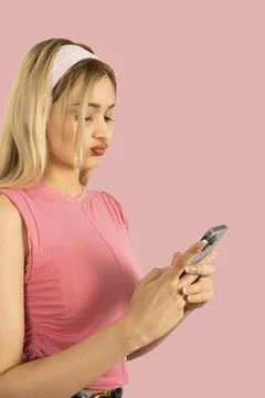 Close up side view blonde sad bored girl using smartphone. Stock Photos