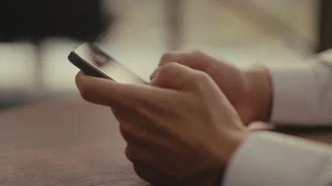 Close-up side view of businessman in white shirt using modern smartphone. Male Stock-Footage 342934065