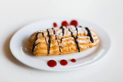 The close-up side view of the cake decorated with chocolade and jam placed on Stock Photos