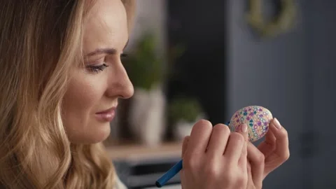 Close up side view of cheerful caucasian woman decorating easter eggs in the dom Video stock 170489167