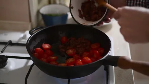 Close up side view of cherry tomatoes frying in a pan with olives Vídeos de archivo 328255760