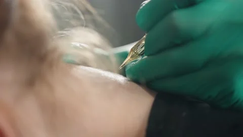 Close-up side view of client's neck, master makes tattoo with tattoo machine. Stock Footage 219549237