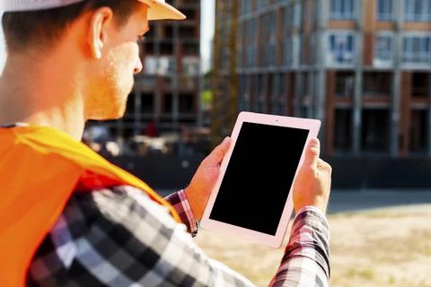 Close up side view construction engineer using tablet Stock Photos
