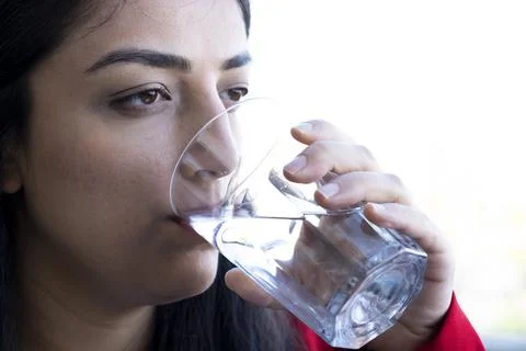 Close up side view cropped image woman enjoys glass of pure water. Stock Photos