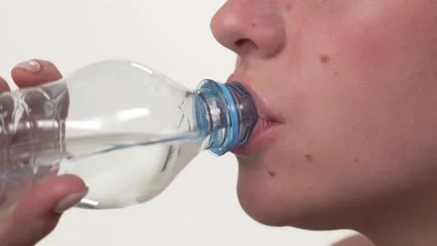 Close up side view of a cropped white woman face. Drinking water from bottle. Vídeo Stock 197410625