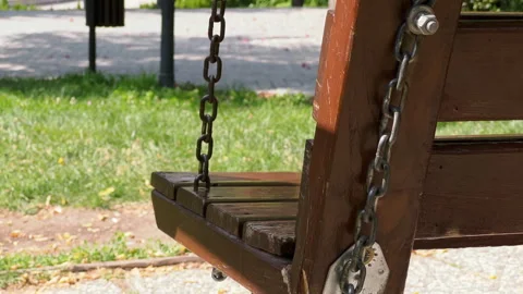 Close-up side view of an empty wooden swing on a park Stock Footage 256157890