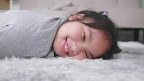 Close up side view of girl lying on floor in living room, looking at camera Stock Footage 172058836