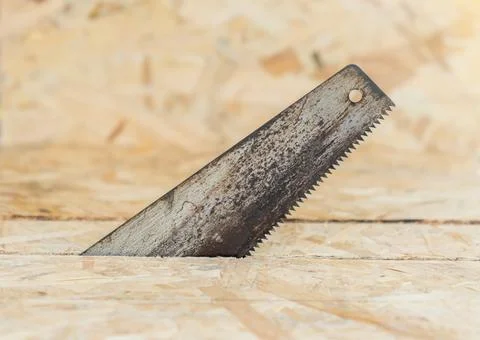 Close up side view of hand saw cutting wood plank. Stock Photos