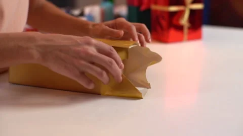 Close-up side view hands of unrecognizable young woman wrapping festive Video stock 163413509