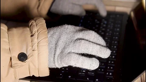 Close up side view of hands in warm gloves typing on a laptop keyboard Stock Footage 328063039