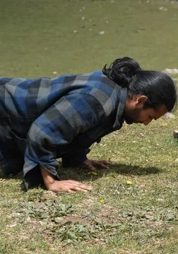 Close up side view of a handsome long haired Indian young man doing push ups  Stock Photos