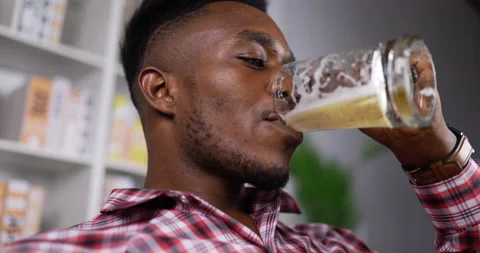 Close up, Side view of Happy african man drinking beer with happiness on relax Видео 200813927