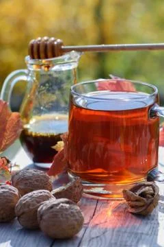 Close side view on hot herbal tea in glass cup with buckwheat honey Stock Photos