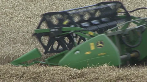 Close side view of John Deere combine harvester on wheat. Stock Footage