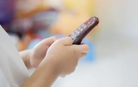 Close-up side view of a kid using television remote control. Stock Photos