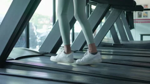 Close up side view of legs girl running, jogging with cardio training on trac Video stock 217748628
