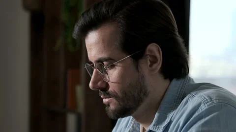 Close-Up Side View of A man with Glasses, Blue Shirt and White t-Shirt Working Stock Footage 143479053