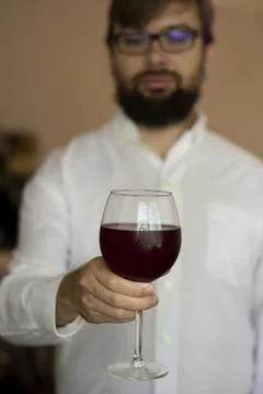 Close up side view of man holding glass with red wine enjoying summer mood and Stock Photos