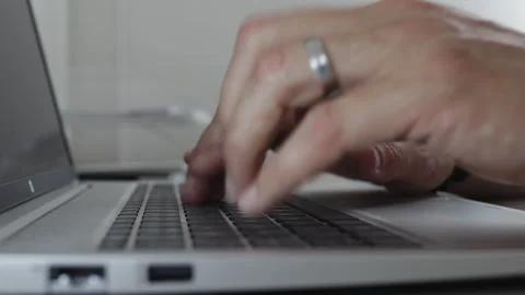 Close up side view of a man's hands rapidly typing on a laptop keyboard at .. Stock Footage 339078696