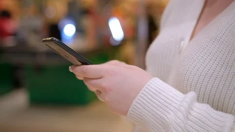 Close up side view millennial woman holding cellphone, swiping photos in online Stock Footage 239925861