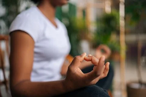 Close-up side view of mindfulness unrecognizable African woman putting hands in Stock Photos