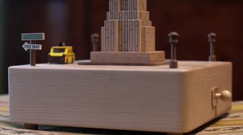 Close side view of music box with taxi going around Empire State Building Stock Footage 67634507