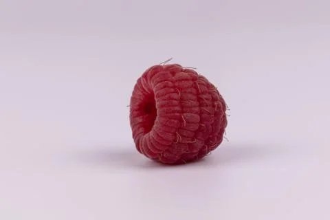 Close side view of one organic natural red juicy raspberry Stock Photos