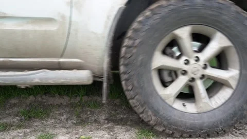 Close-up side view of a passing dirty powerful SUV. Motion the wheels tires and Stock Footage 241888222