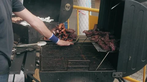 Close-up side view of person checking brazier surface of black metal grill using Video stock 292883557