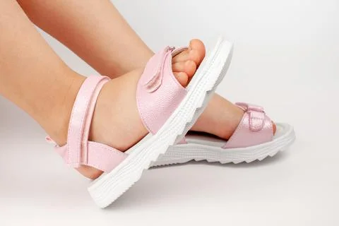 Close-up side view of pink children's leather sandals with flat soles, two co Stock Photos