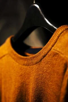 Close Up Side View Of Plain Orange Sweatshirt on Hanger, Isolated on Black .. Stock-Fotos