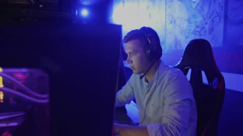 Close-up side view portrait shot of young man with headset losing shooter game Video stock 136380455