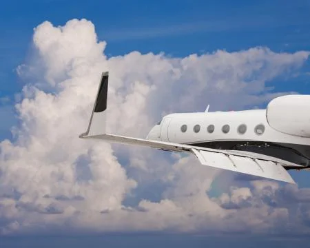Close side view of a private jet flying Stock Photos