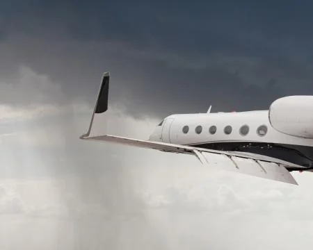 Close side view of a private jet flying Stock Photos