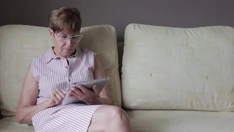 Close up side view of retired senior woman using digital tablet Stock Footage 156738556