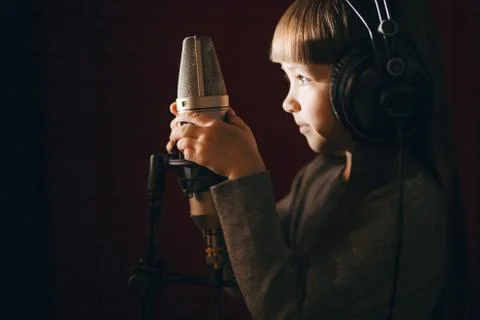 Close up side view shot. shy little girl in the music recording studio Stock Photos
