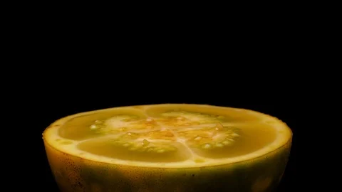 Close-up side view, solanum quitoense naranjilla fruit sliced in half slowly Stock Footage 105797634