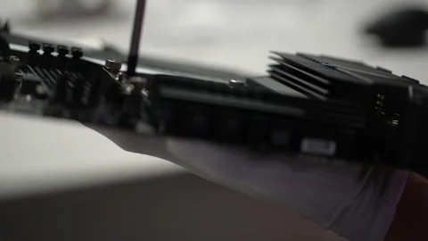 Close-up side view of unrecognizable technician in gloves screwing in PC CPU air Stock Footage 234323548