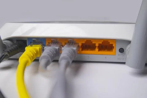 Close-up side view of a white wireless router back panel with connected Eth.. Stock Photos