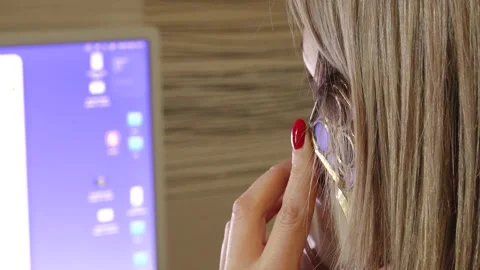 Close-up side view of a woman holding a gold smartphone to her ear, with blonde Stock-Footage 336466097