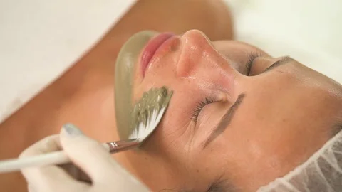 A close up side view of woman's face. A hand in a white rubber glove Stock Footage 96189734